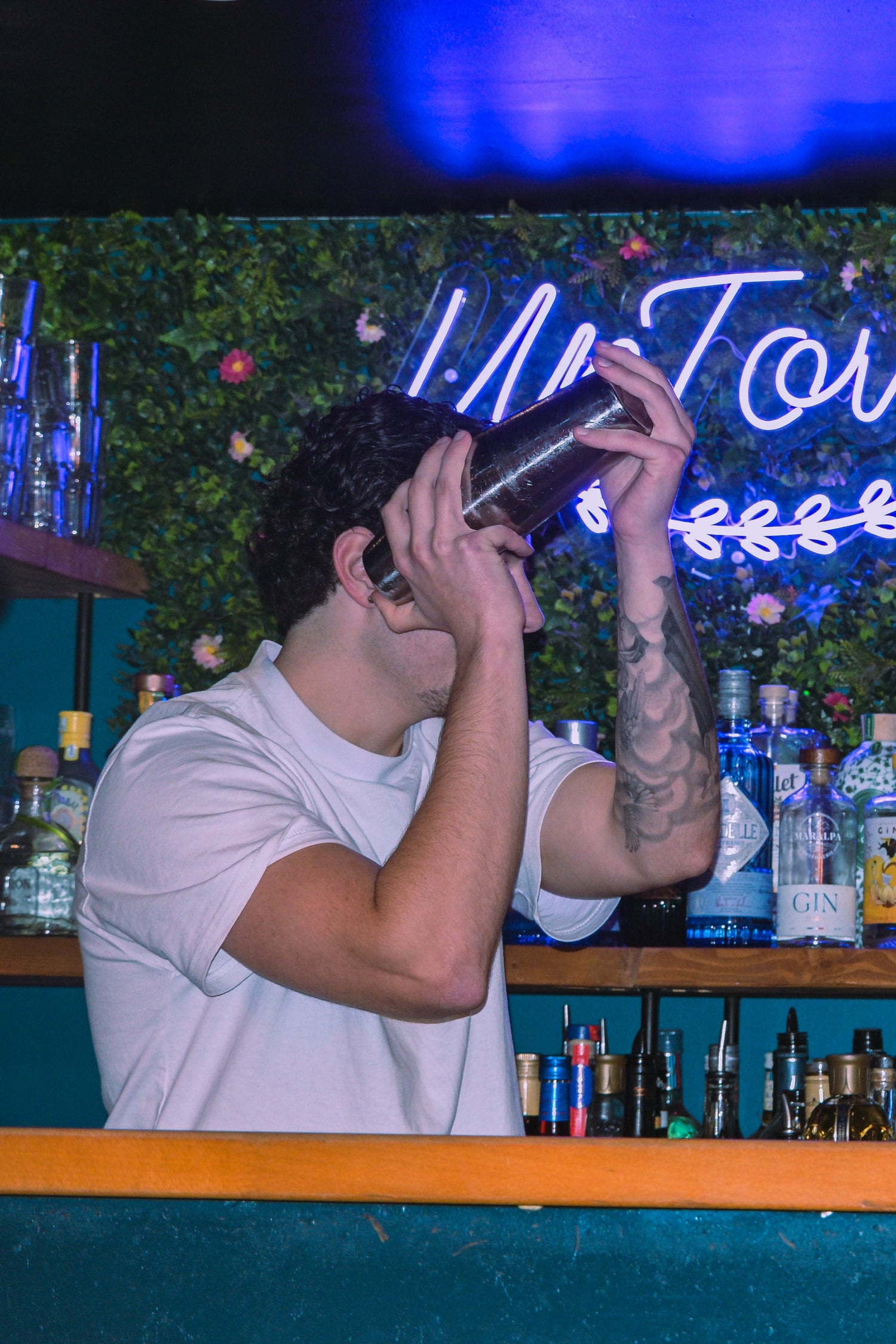 Bartender shaking a cocktail during a cocktail workshop in Nice Old Town, interactive mixology class in a local bar on the French Riviera.
